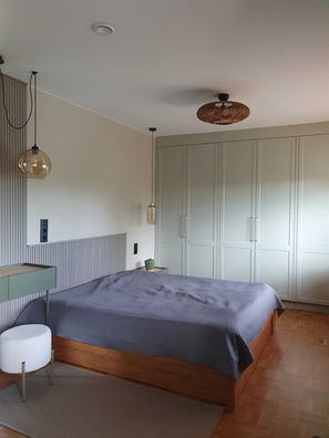przytulna sypialnia, lampy boho, na ścianie lamele w kolorze taupe ciemny,  lampy wiszące szklane, posadzka klasyczna mozaika parkietowa prl układana w szachownicę