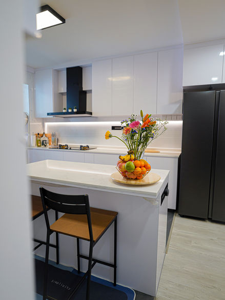 White kitchen island with fruit bowl and flowers