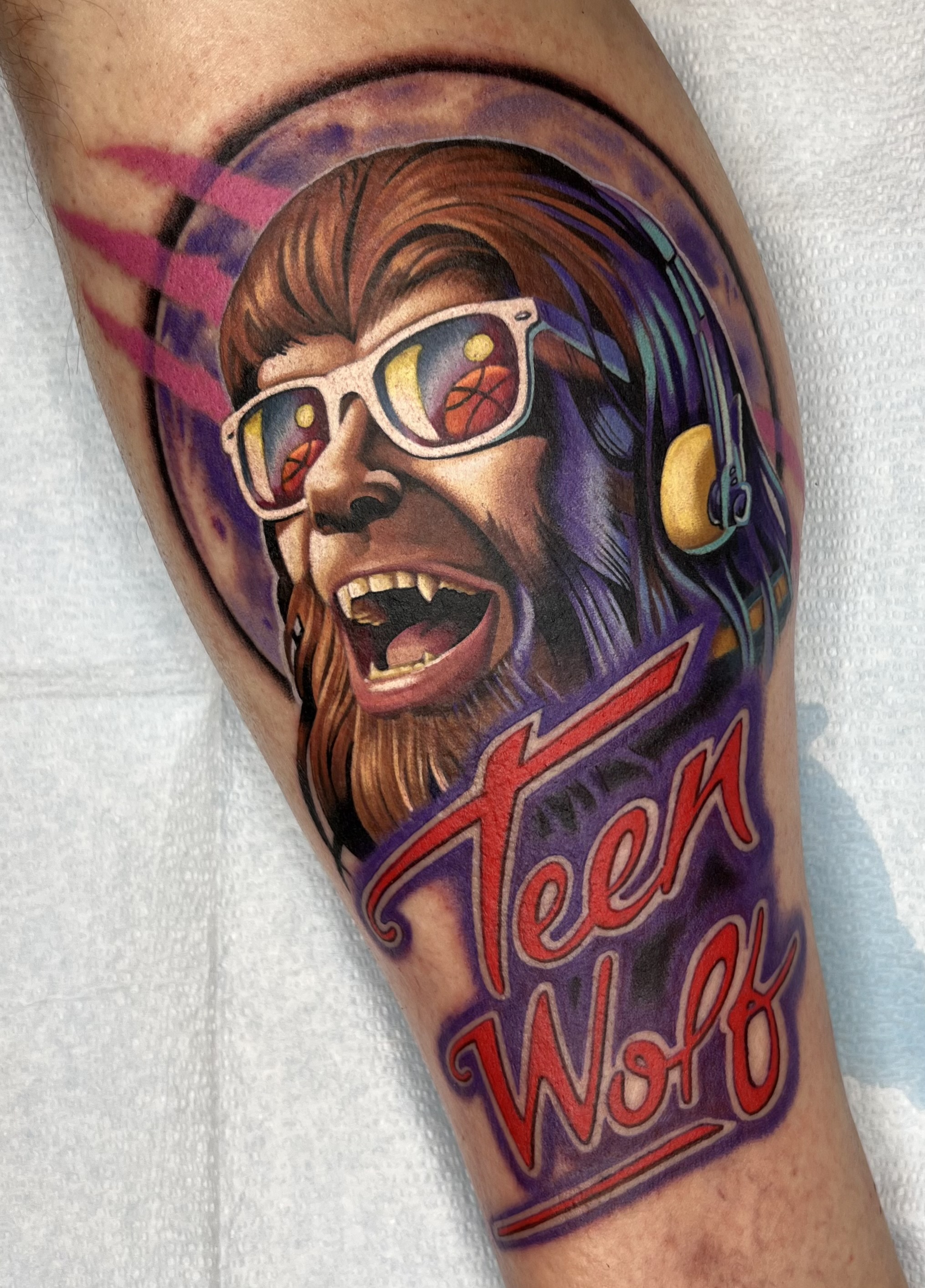 Colour portrait of a bearded sports fan in glasses and a headset with red lettering