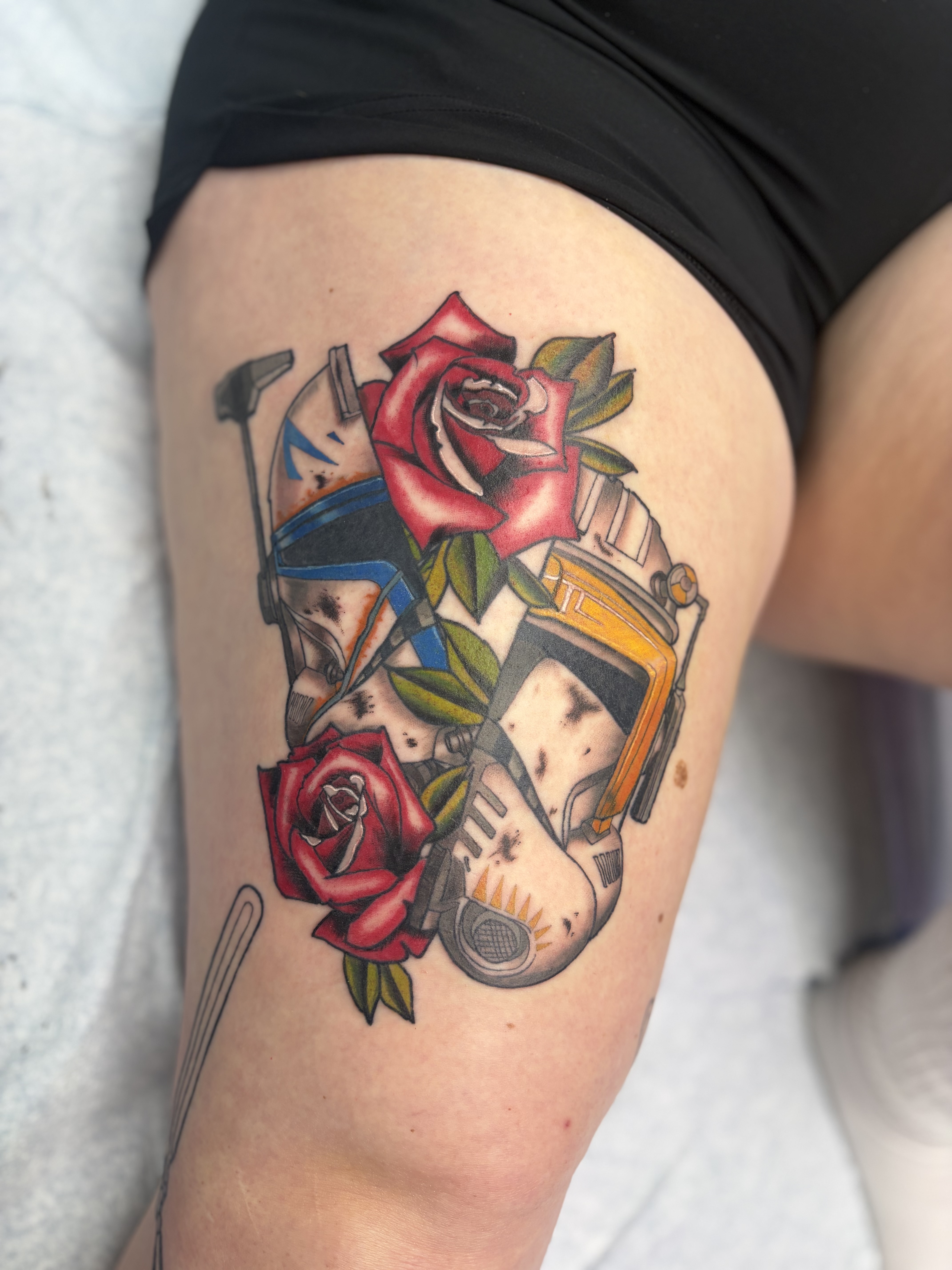 Red roses layered over a camera and geometric fragments on the thigh