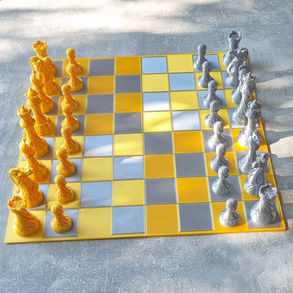 Goud en zilver 3D-geprint schaakbord met alle schaakstukken opgesteld.