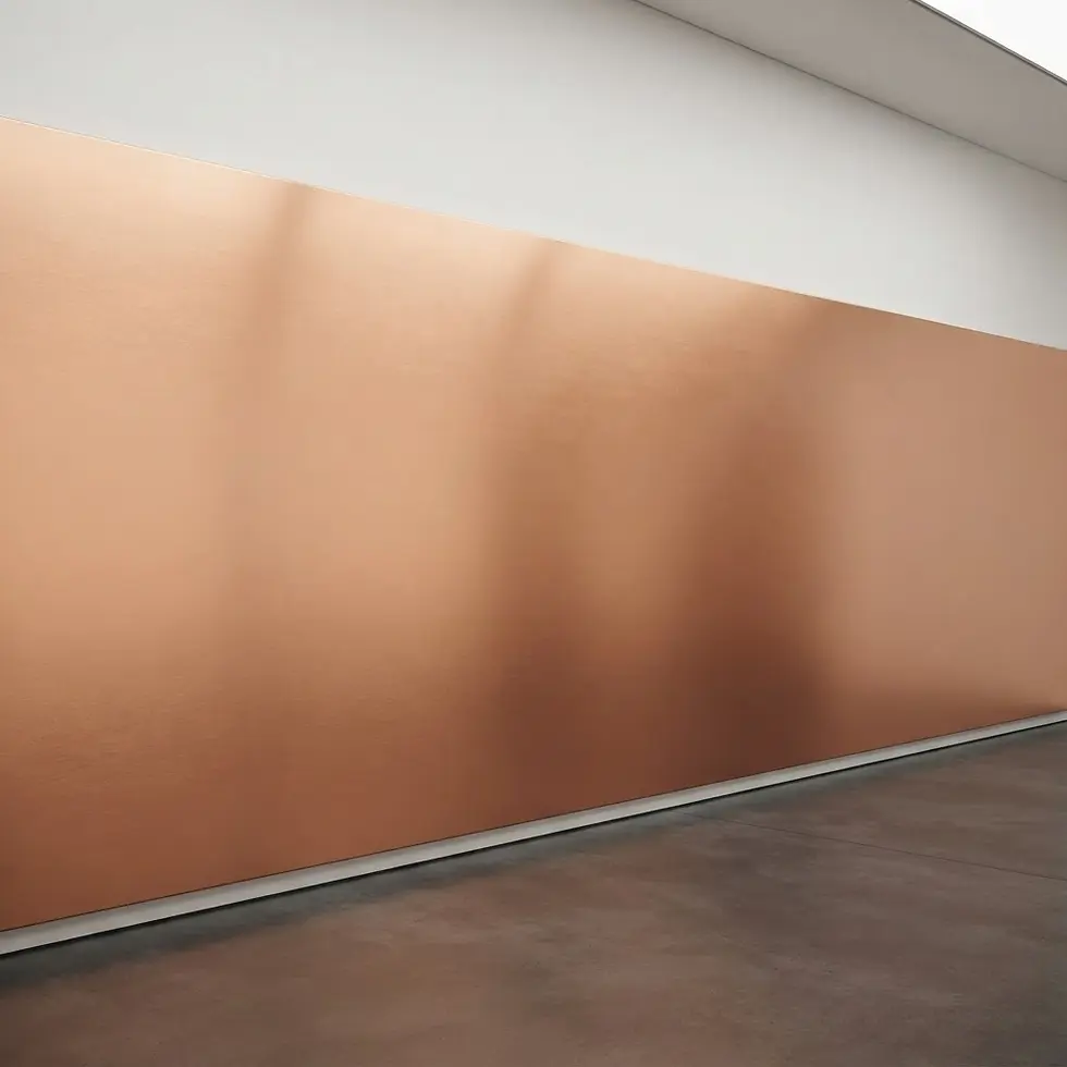 Interior photography of a large wall with a brushed metallic finish, possibly copper. The smooth surface features subtle shadows and highlights, creating a minimalist and elegant aesthetic.