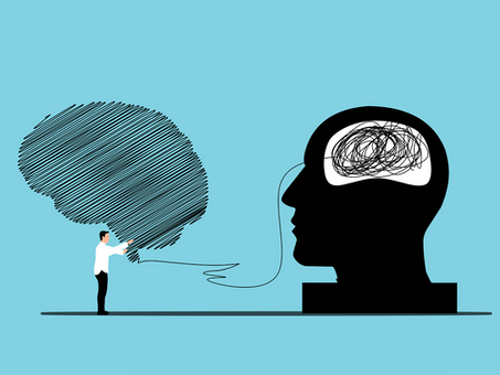 A person holds a large scribbled brain connected by a line to a silhouette with a tangled brain. Blue background, concept of communication.