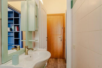 Zona lavabo del bagno della Casa di Nene con specchio e mobiletti verdi