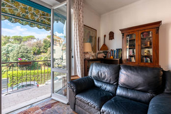 Soggiorno di Casa Relax con divano in pelle e portafinestra aperta sul giardino