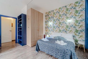 Camera da letto della Casa di Nene con armadio in legno e libreria blu
