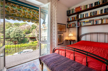 Camera da letto di Casa Relax con portafinestra aperta sul terrazzo e libreria a parete