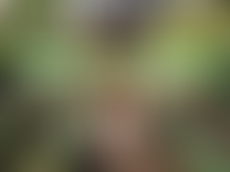 a photorealistic image of a beautiful African American woman standing barefoot in soil in a garden, near her feet are newly planted rows of flowers; Lightworkers Garden