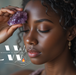 The 8 Clair Senses - Beautiful African American woman holding amethyst crystal to her forehead