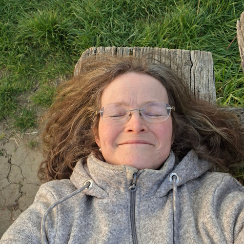 Sindy Grambow, Biologin und Stresscoach, entspannt im Grünen – Traumintelligenz. Über mich.