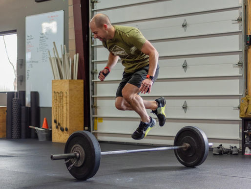 Man jumping over barbell