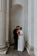 Wedding couple kissing under an archway