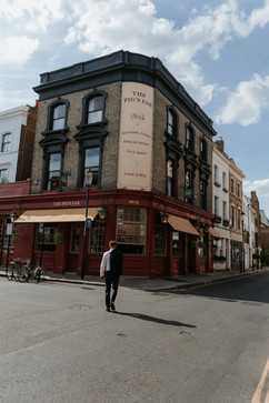 groom walks towards the pub called the pigs ear