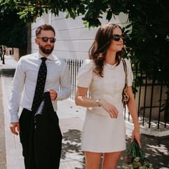 35mm film bride and groom stand on a street corner