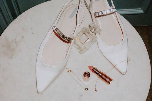White shoes with sparkly straps, perfume, lipstick, and jewelry