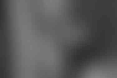 blurred black and white image of bride and groom getting ready at home together