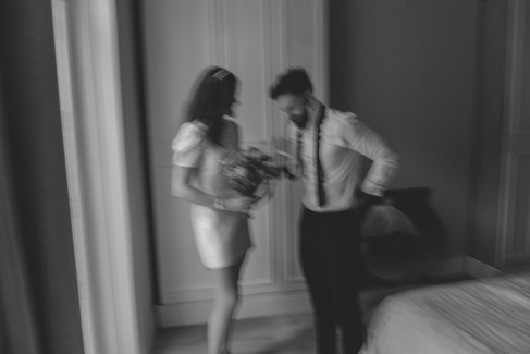 blurred black and white image of bride and groom getting ready at home together