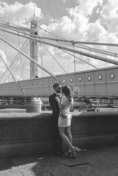 bride and groom kiss whilst standing next to the Albert Bridge in London
