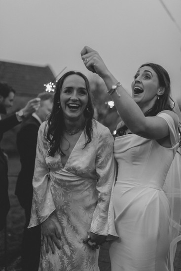 black and white image of a sparkler tunnel for two brides