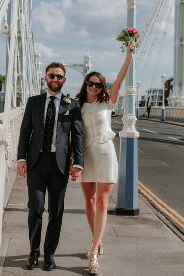 bride and groom gaze to each other whilst walking along the street