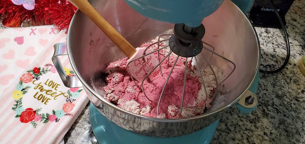 Mixing bowl with white and pink ingredients being mixed together
