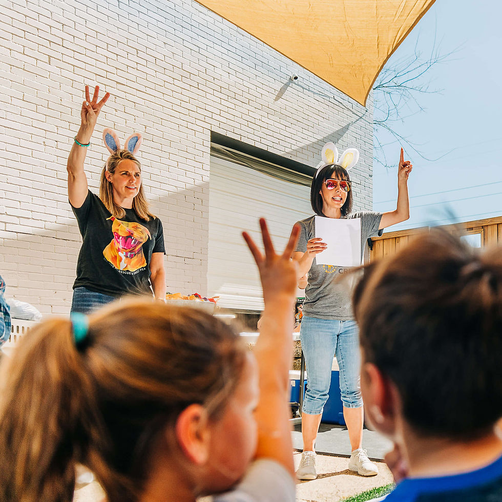 Children watching two volunteers speak to them at an event