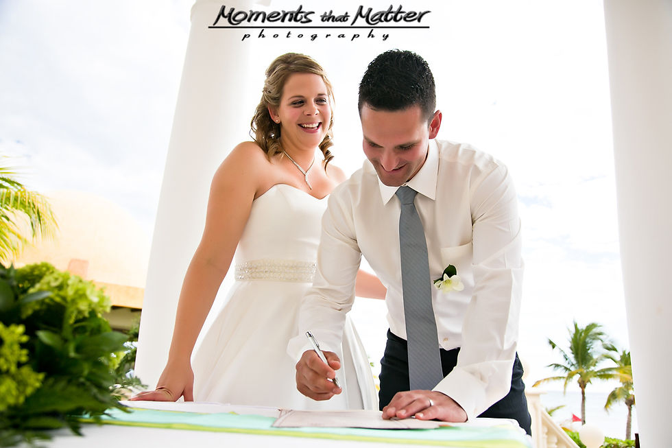 Charmaine and Aidan signing during their Barcelo Maya Palace wedding