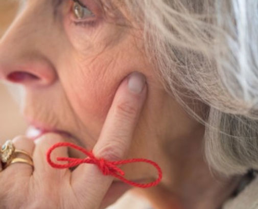A women with a string on her finger to represent memory loss