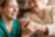 A therapist holding the hand of an elderly person