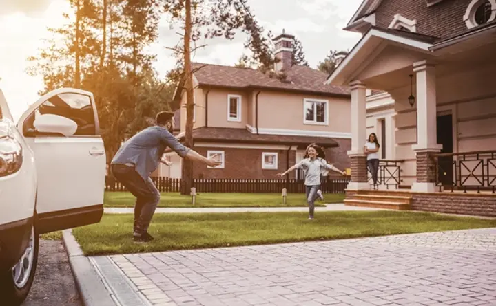 Happy family arriving home, child running to father