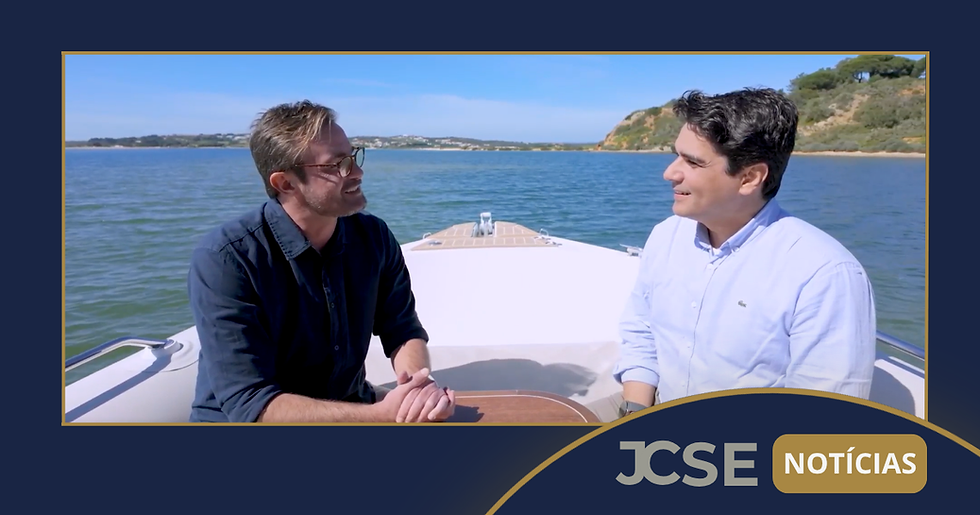 A imagem mostra João Coelho, fundador da JC Saúde Empresarial, e o apresentador Max Fercondini conversando durante entrevista sobre eficiência hospitalar, entre outros assuntos, a bordo de um barco no Algarve, Portugal. A imagem traz o logotipo do portal JCSE Notícias no canto inferior direito.
