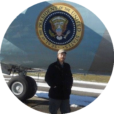An image of Pivo founde John Marble, a white man, standing in fron of Air Force One.