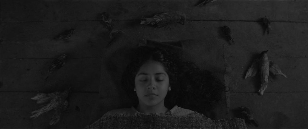 Sorcery_Movie still_Valentina Véliz Caileo as Rosa Raín lying on the floor with closed eye