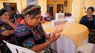 A midwife in Joyabaj studies a life-size model of a 6-month baby in the womb—part of a growing vision to bring dignified, life-saving care to rural Guatemala