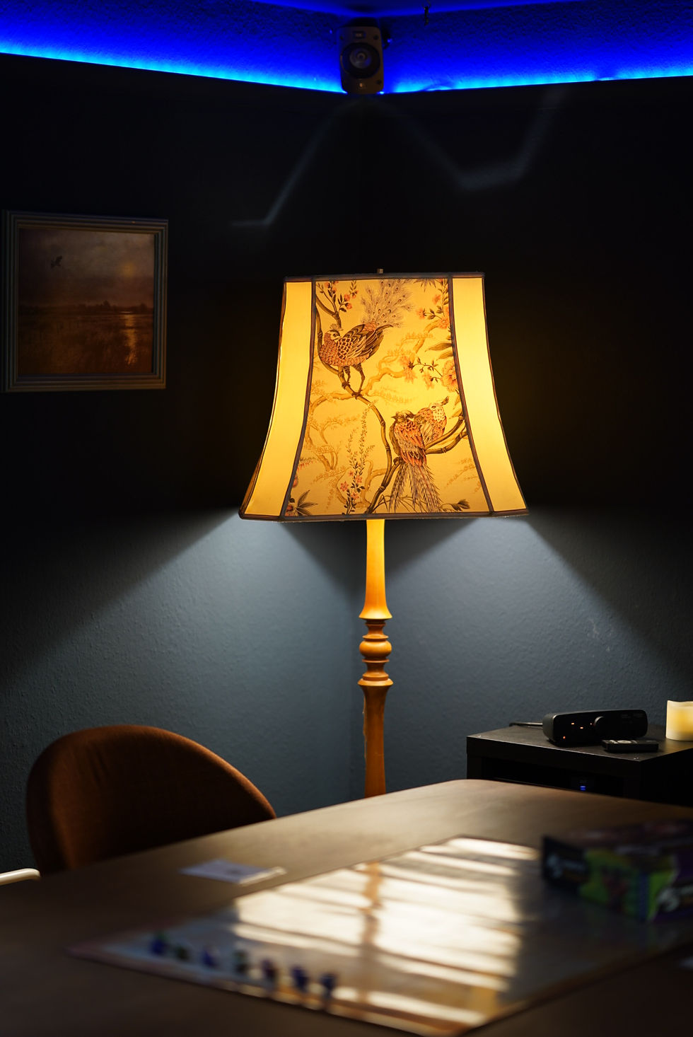 Bild einer Stehlampe, die leicht einen Tisch mit Würfeln beleuchtet An der Wand LED Beleuchtung und Lautsprecher