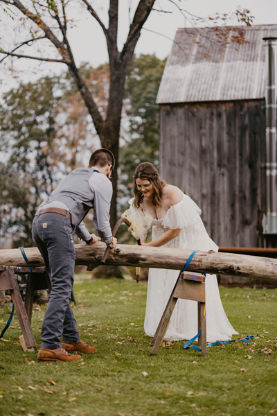 A couple sawing a log