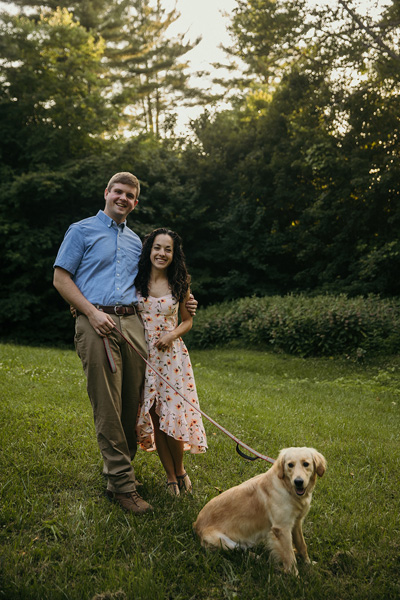 A couple smiling with a dog