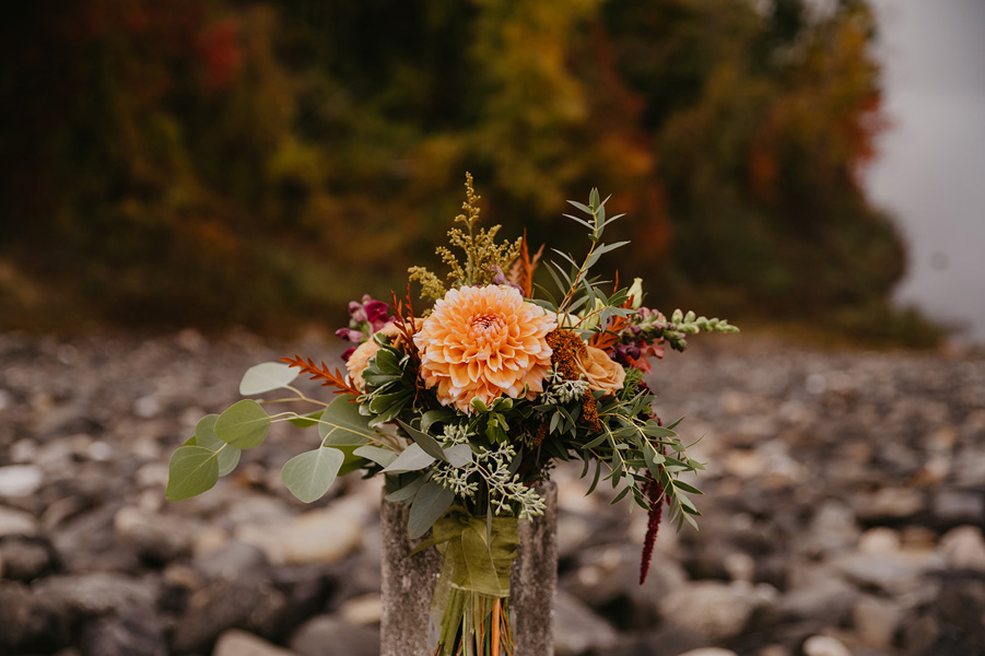 A vase of flowers sitting on rocks
