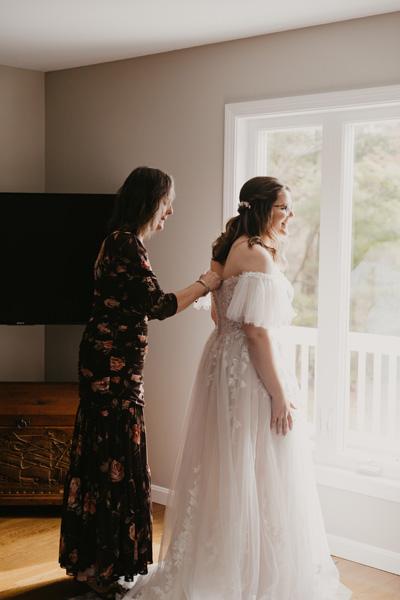 A mother helping daughter zip dress