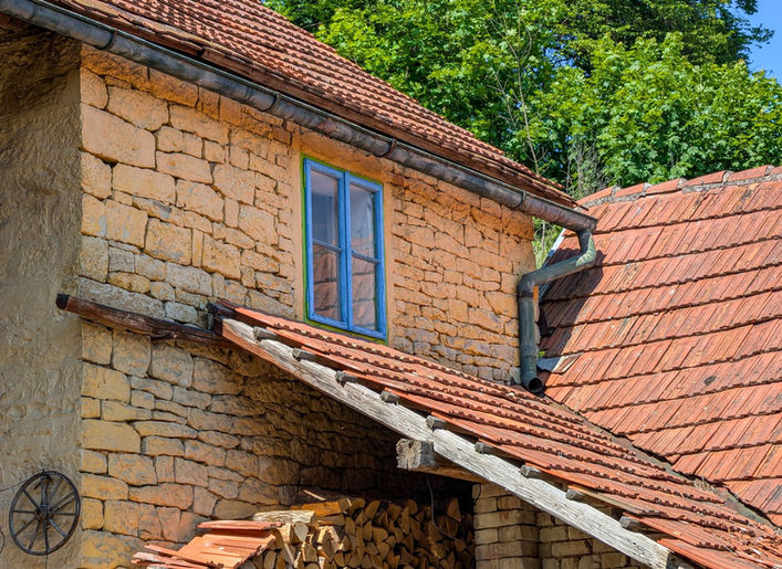 Detail kamenné fasády a střechy domu v Javorníku u Vysokého Mýta.