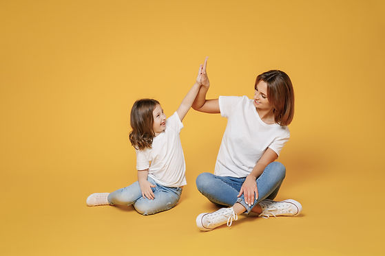 Full body length happy woman in basic white t-shirt have fun sit on floor with child baby