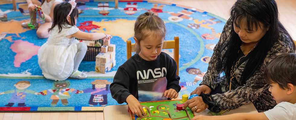 Children playing with one of our staff on a carpet and low table