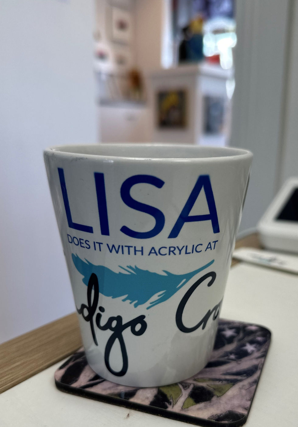 a mug sitting on a desk with the gallery in the background