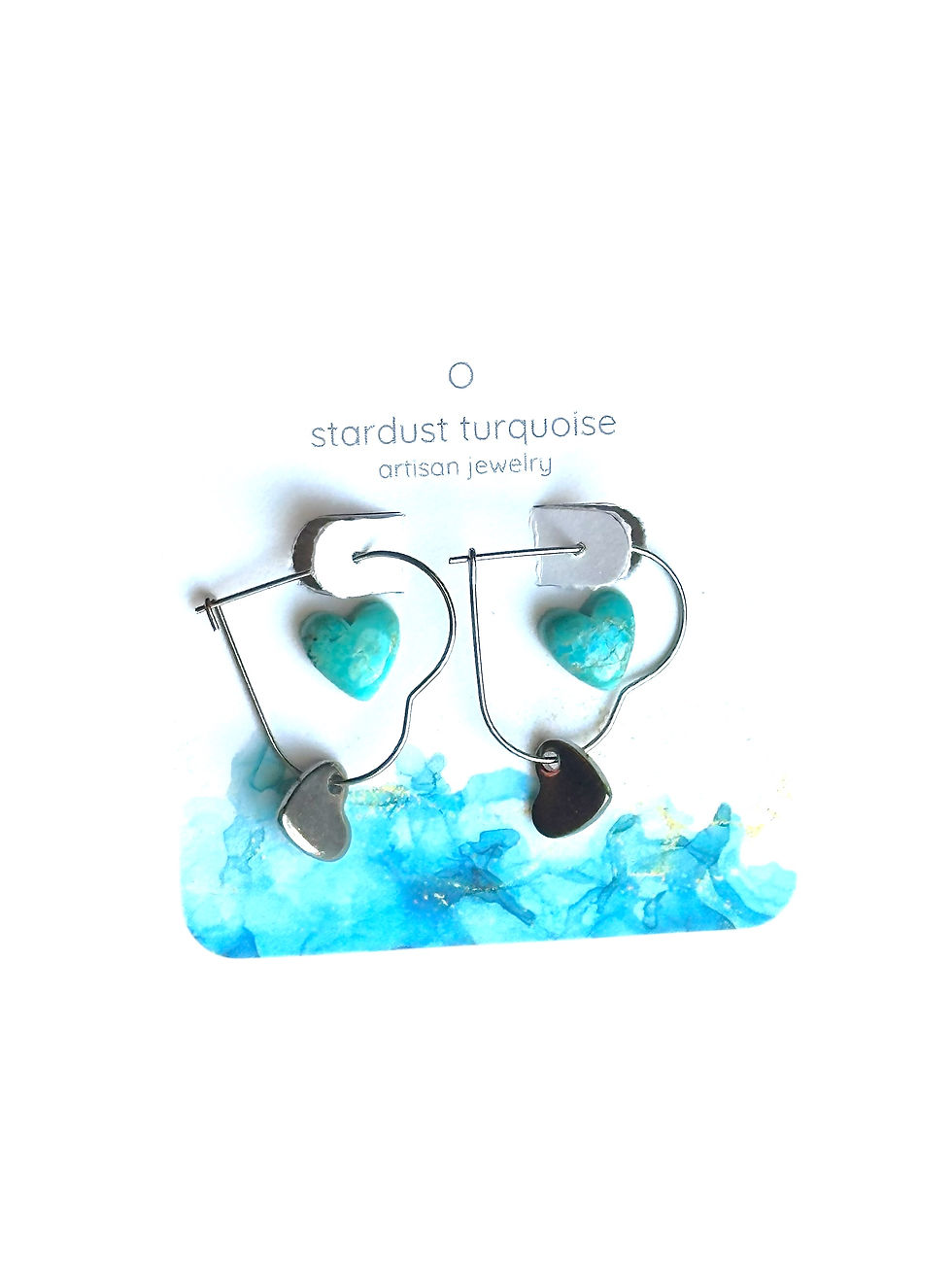 Two pairs of earrings on a decorative earring card, one set heart turquoise studs the other stainless steel heart hoops.
