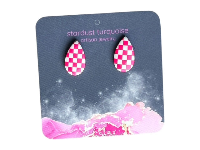 A large pair of pink and white checkered pear shape stud earrings on a dark earring card.