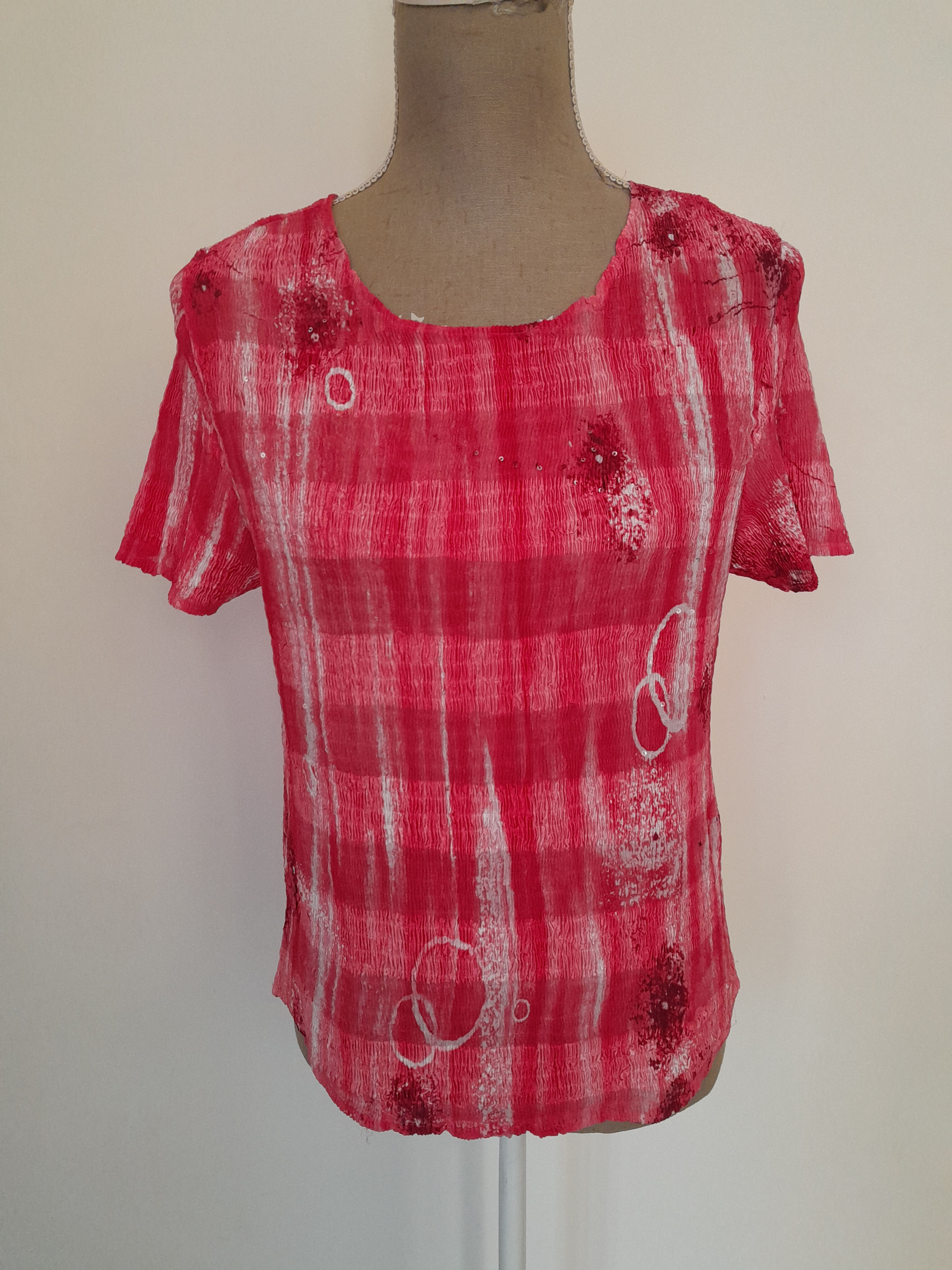 T-shirt rose et blanc, motif floral, présenté sur un mannequin de magasin, Seconde Main.