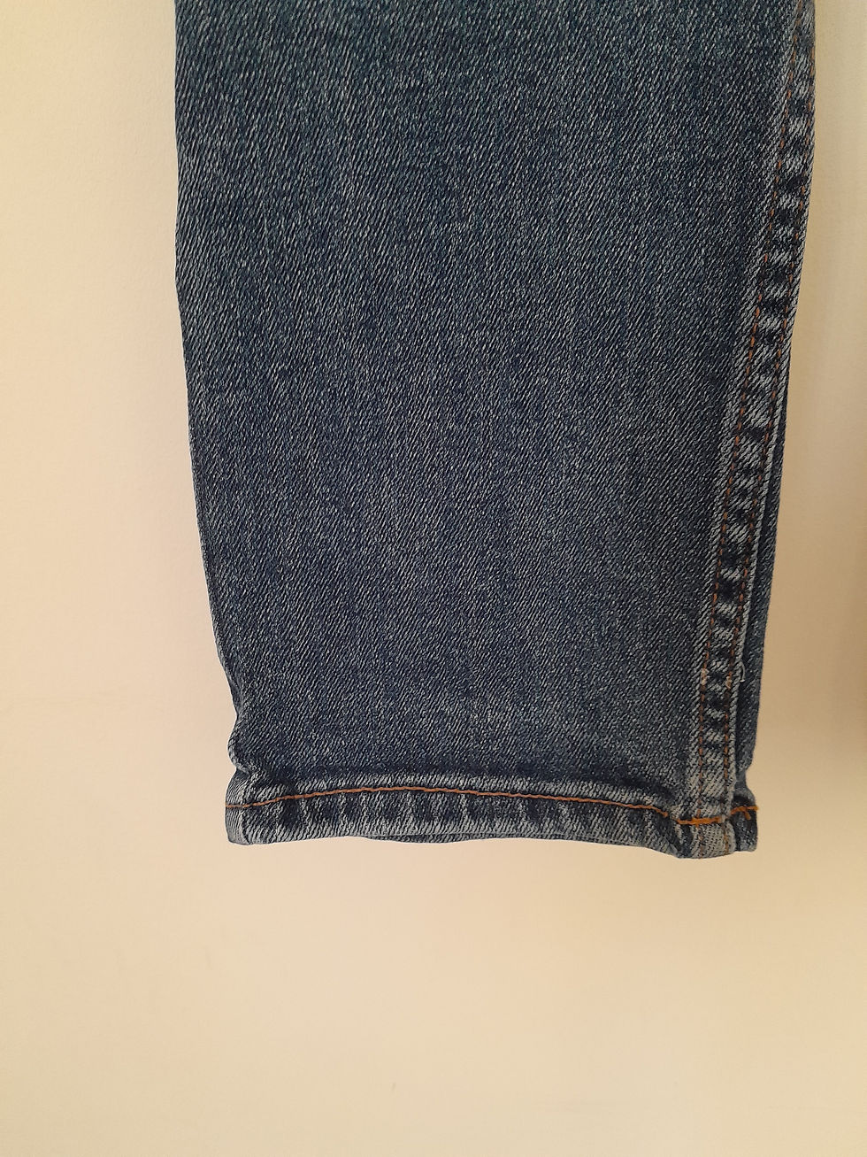 Miniature : Détail du bas d'un jean bleu, couture visible, Seconde Main.