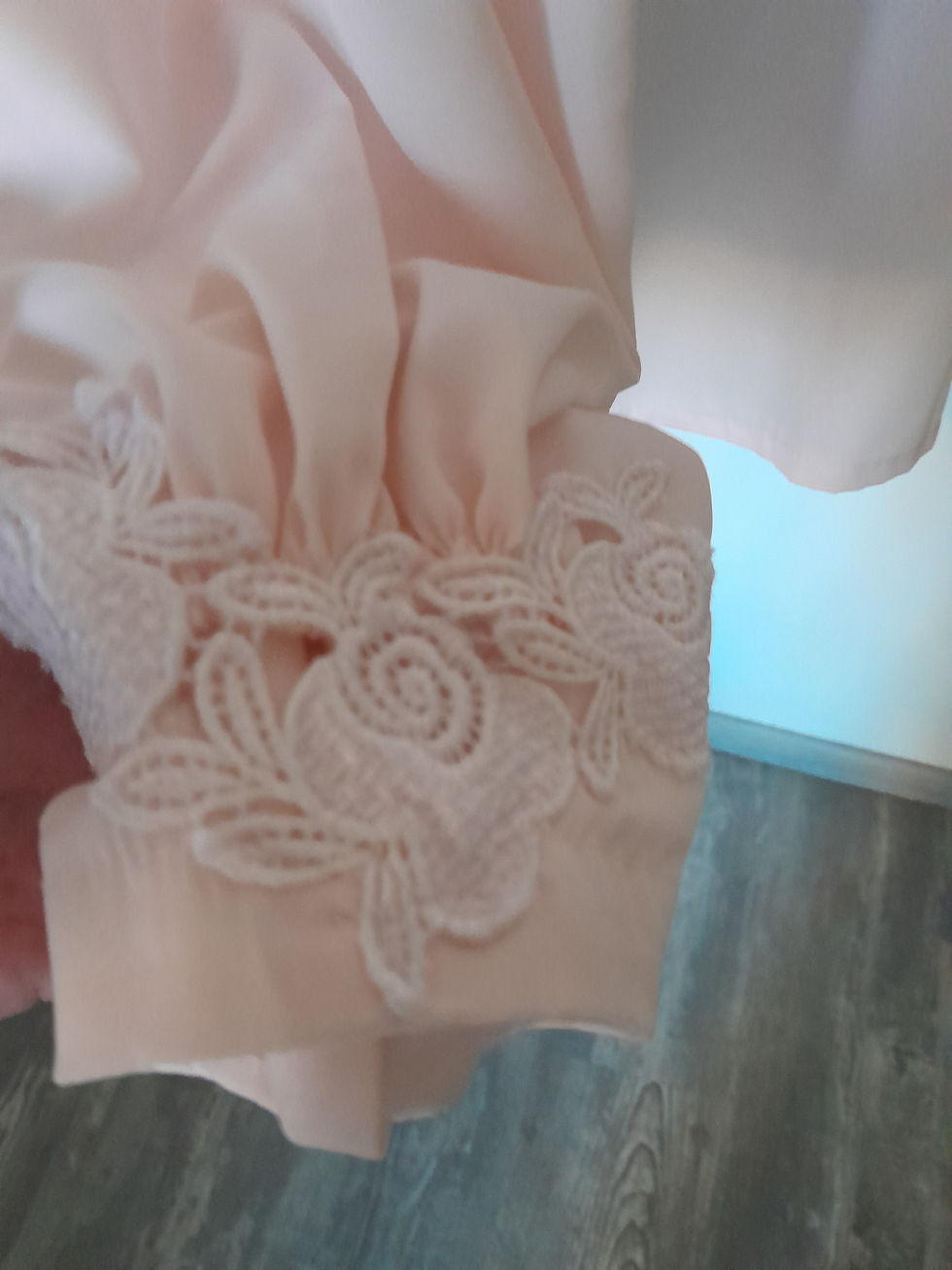 Miniature : Détail d'une manche rose clair avec dentelle en forme de roses. Jupe. Seconde main.