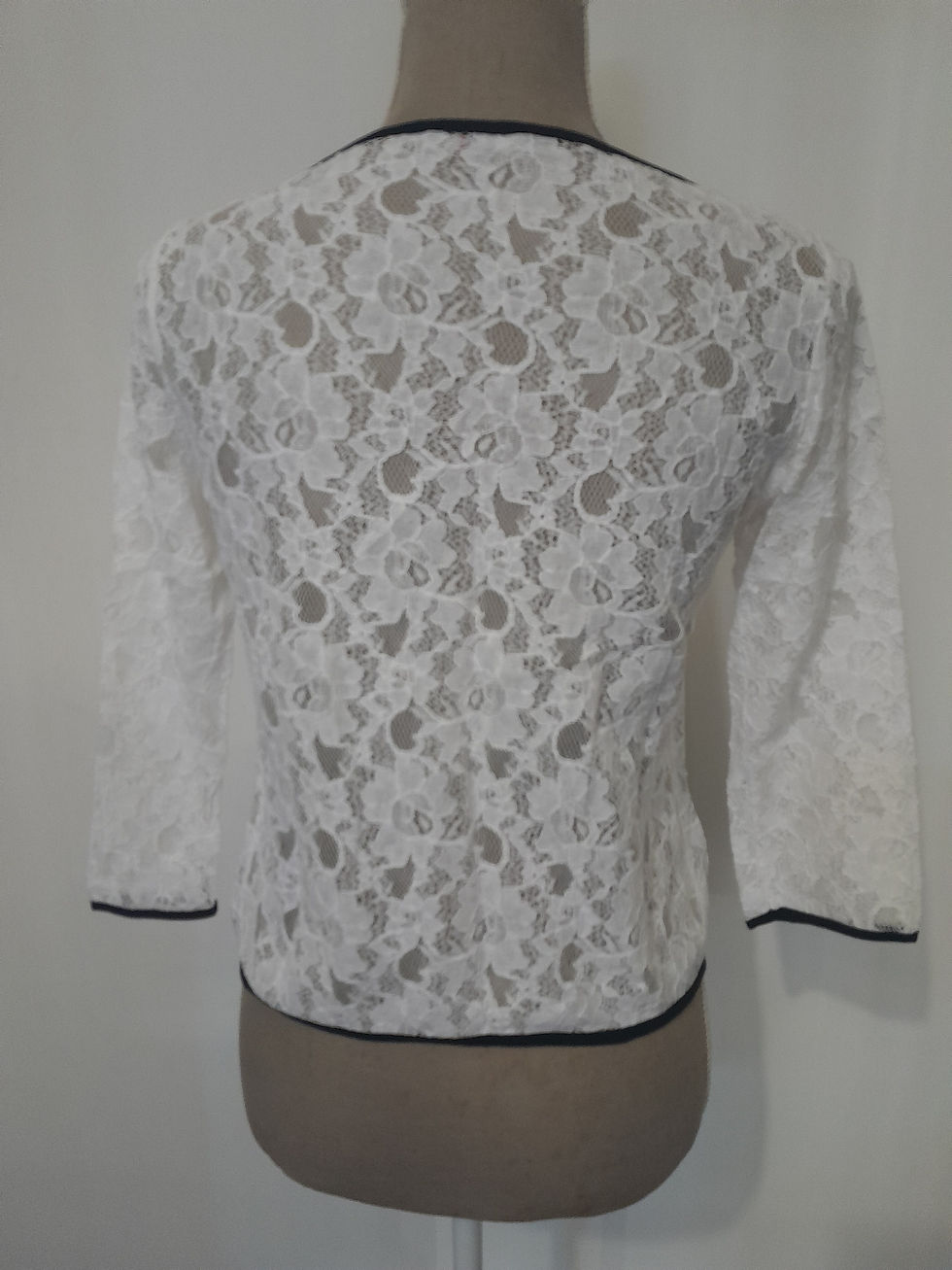 Miniature : Dos d'une veste blanche en dentelle, détails noirs, seconde main, élégante.