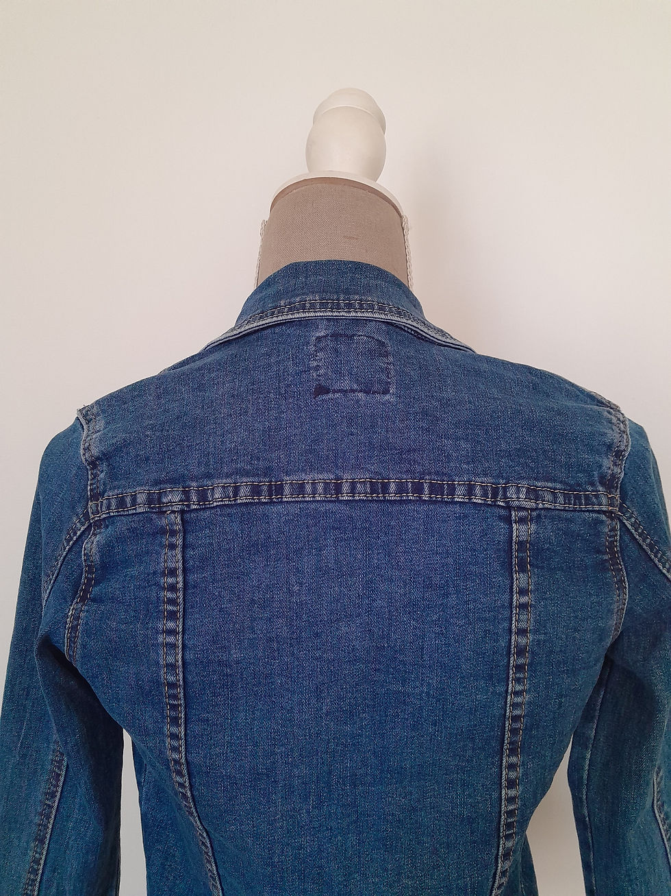 Miniature : Détail du dos d'une veste en jean bleue, sur un mannequin.